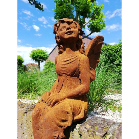 Garden sculpture of a sitting fairy - romantic garden design