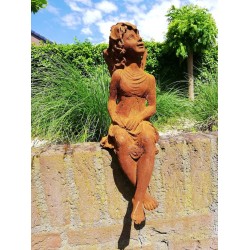 Garden sculpture of a sitting fairy - romantic garden design